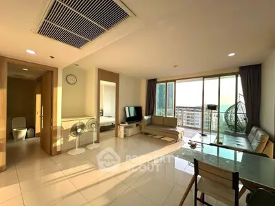 Spacious living room with modern furniture and large windows offering city views.