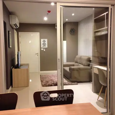 Modern living room with sleek furniture and glass partition in a stylish apartment.