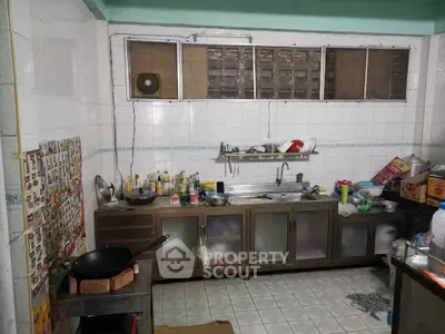 Spacious kitchen with tiled walls and ample storage in a cozy home.