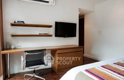 Modern bedroom with sleek desk, wall-mounted TV, and stylish decor