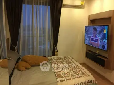 Cozy bedroom with large window and wall-mounted TV, perfect for relaxation.