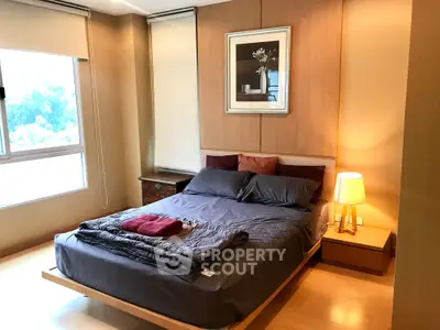 Cozy bedroom with modern decor and large window offering natural light