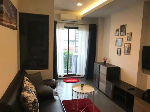 Cozy living room with modern decor and balcony access in urban apartment.