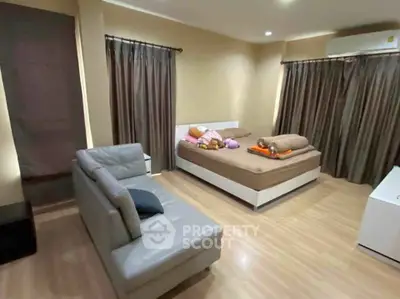 Spacious bedroom with modern decor and cozy seating area, perfect for relaxation and comfort.