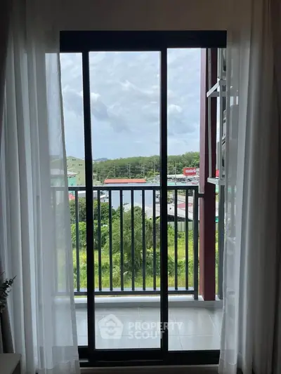 Spacious balcony with scenic view through sliding glass doors, perfect for relaxation and enjoying nature.