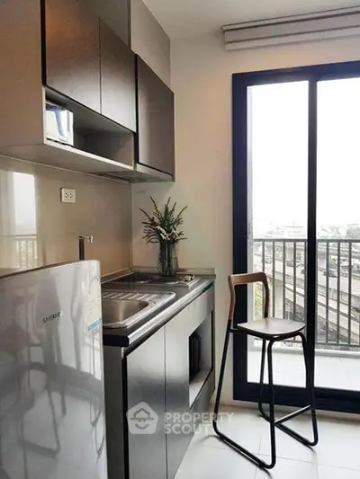 Modern kitchen with sleek cabinetry and balcony view, perfect for urban living.