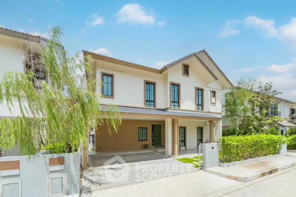 Modern two-story house with spacious driveway and lush greenery in a serene neighborhood.