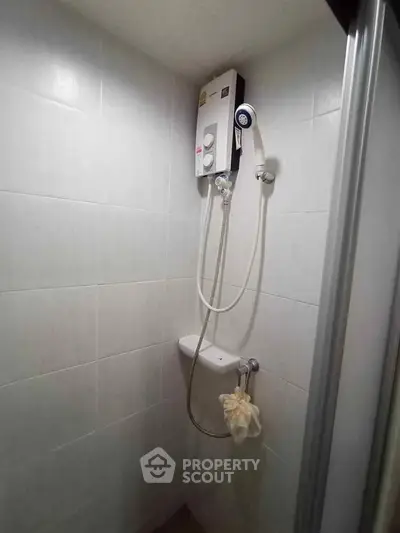 Compact bathroom shower area with wall-mounted water heater