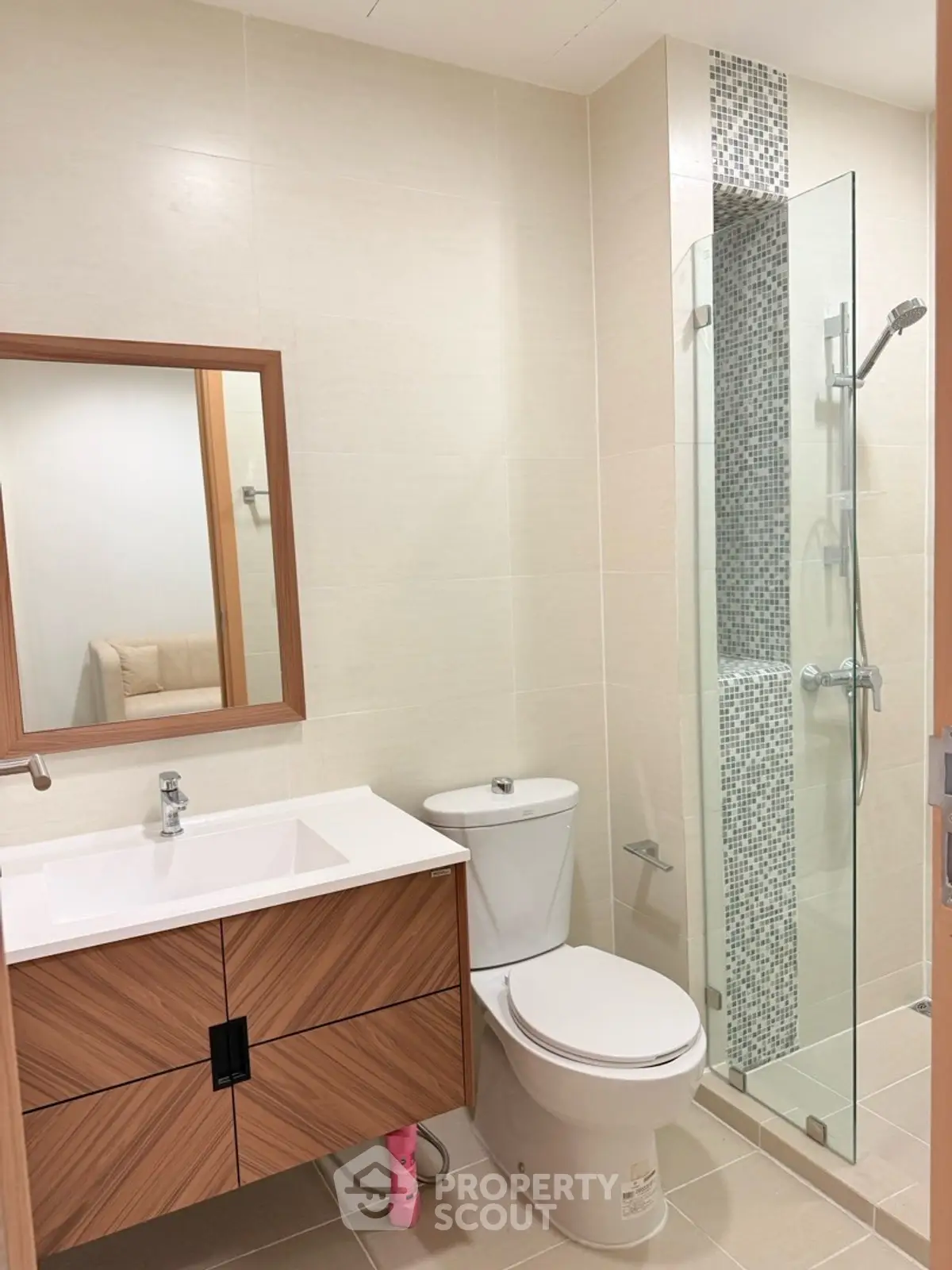 Modern bathroom with sleek vanity and glass shower enclosure in a contemporary apartment.