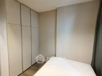 Minimalist bedroom with built-in wardrobe and neutral tones, perfect for modern living.