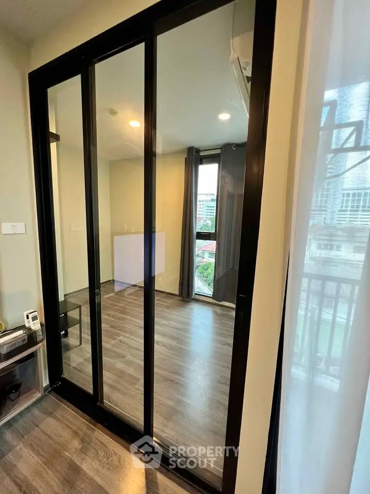Modern apartment with sliding glass doors and city view from balcony.