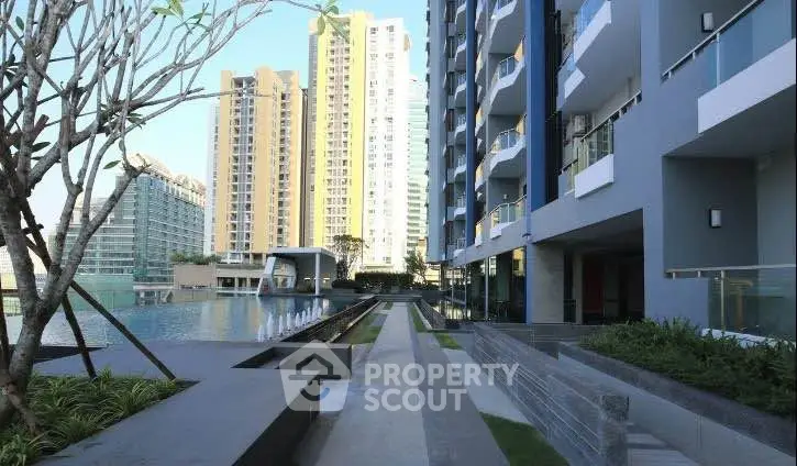 Modern residential building with pool and landscaped garden area, showcasing luxury urban living.