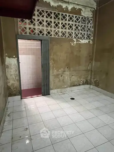 Spacious room with tiled floor and open doorway, ideal for renovation or creative transformation.