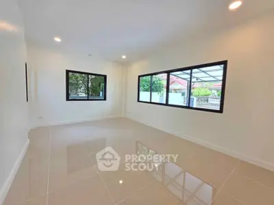 Spacious and bright living room with large windows and glossy tiled floors