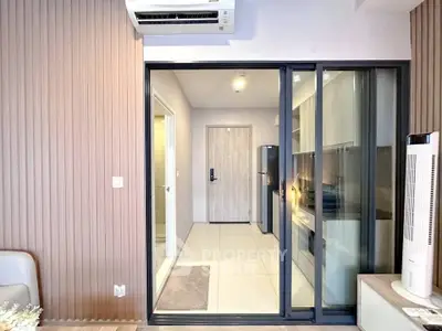 Modern apartment interior with sliding glass doors and sleek kitchen design