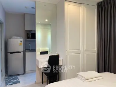 Modern bedroom with built-in wardrobe and compact kitchen area, ideal for urban living.
