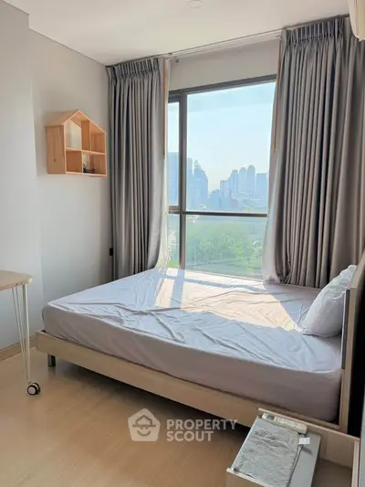 Modern bedroom with large window offering stunning city view, featuring minimalist decor and natural light.
