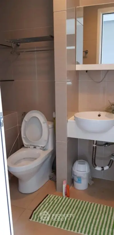 Modern bathroom with sleek fixtures and striped rug