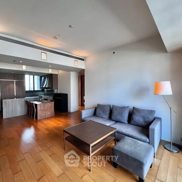 Spacious modern living room with open kitchen and wooden flooring