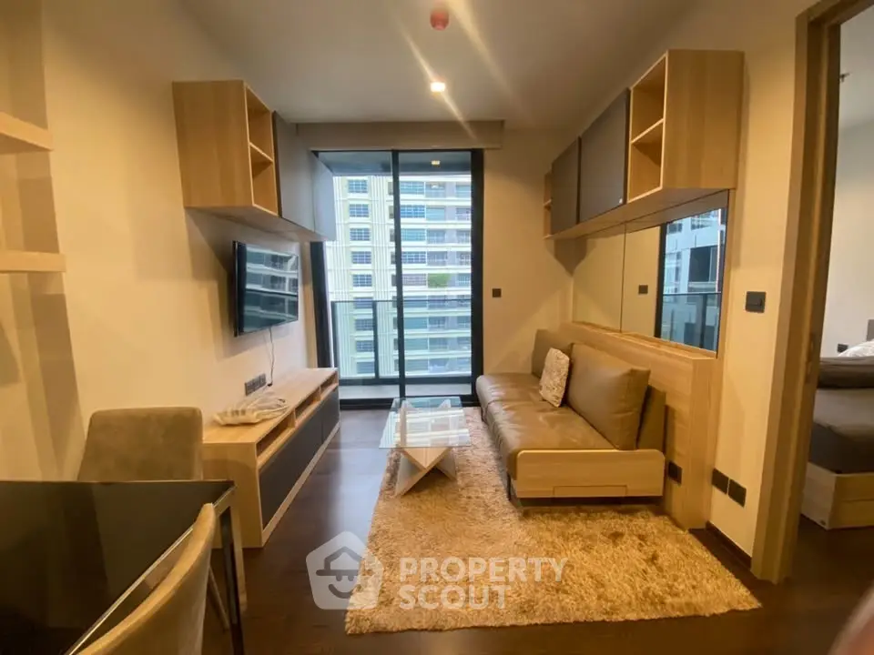 Modern living room with stylish furniture and balcony view in urban apartment.