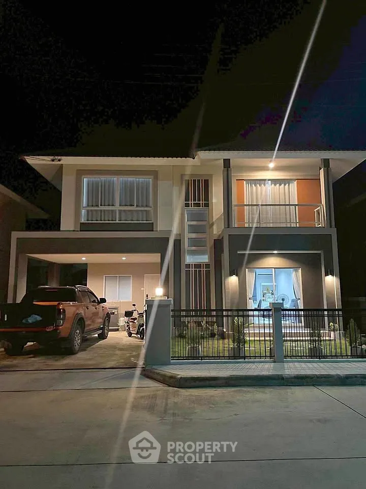 Modern two-story house with spacious driveway and night lighting