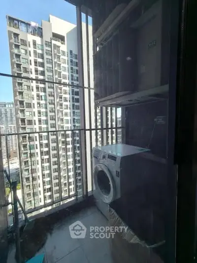 Modern balcony with washing machine and city view in high-rise apartment