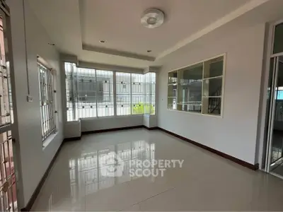 Spacious corner unit with large windows and glossy tiled floors, perfect for natural light and modern living.