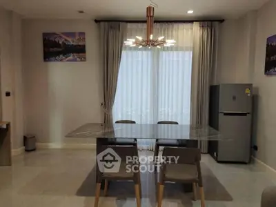 Modern dining area with elegant table, chairs, and large window with curtains.