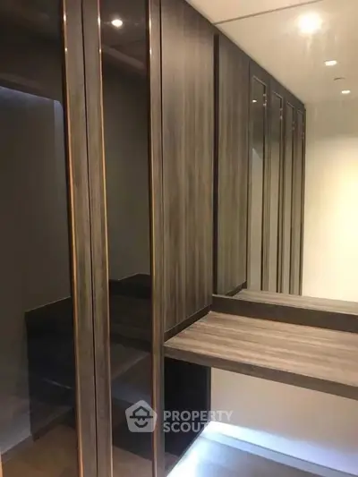 Luxurious walk-in closet with sleek wooden finishes and ample storage space.