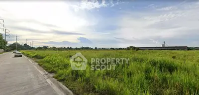 Expansive vacant land with lush greenery and clear skies, ideal for development opportunities.