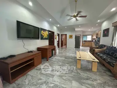 Spacious living room with modern decor and open layout, featuring a wall-mounted TV and stylish furniture.