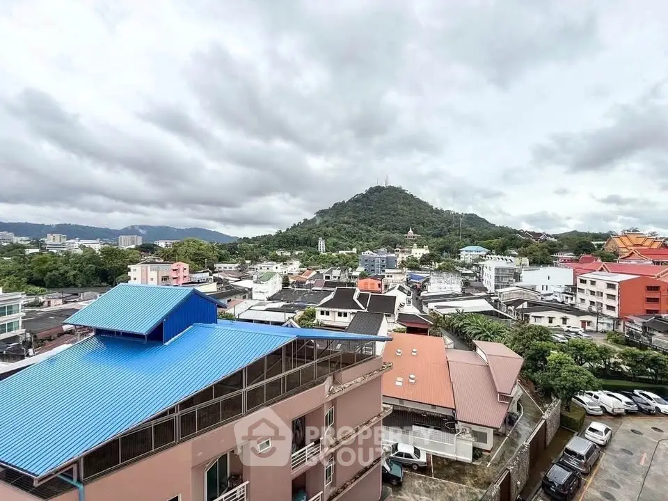 Stunning panoramic view of urban landscape with lush green hills and diverse architecture.