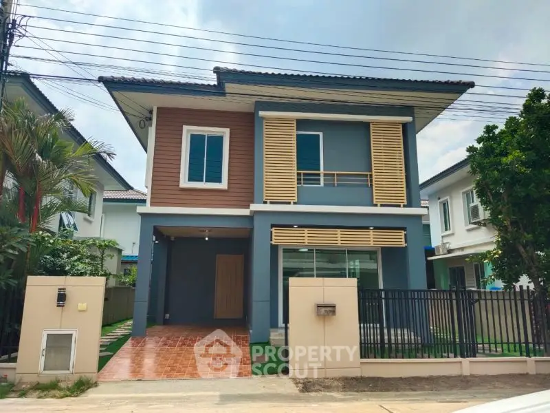 Modern two-story house with stylish facade and gated entrance in suburban neighborhood.