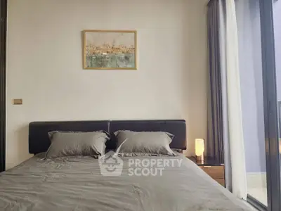 Modern bedroom with stylish decor and natural light from large windows.