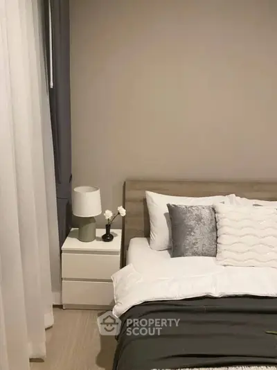 Modern bedroom with stylish decor and cozy ambiance, featuring a sleek nightstand and elegant bedding.