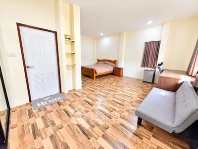 Spacious bedroom with wooden flooring and modern furnishings for a cozy living experience.