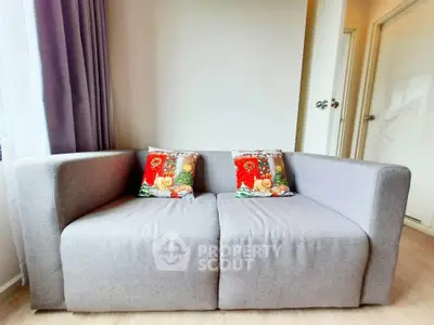 Cozy living room with modern gray sofa and decorative pillows, perfect for relaxation.