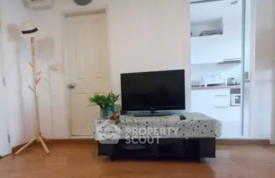 Cozy living room with TV and open kitchen layout, perfect for modern living.