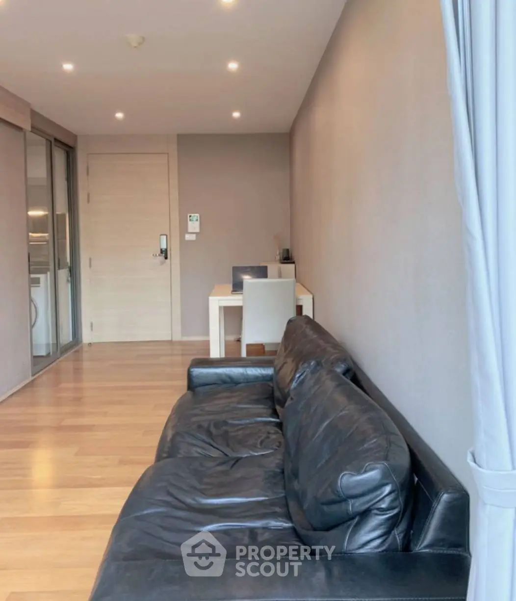 Modern living room with sleek leather sofa and wooden flooring