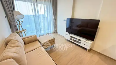 Modern living room with large TV and cozy sofa, featuring floor-to-ceiling windows and elegant decor.