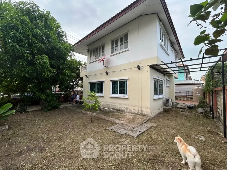 Charming two-story house with spacious backyard and lush greenery, perfect for family living.