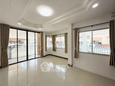 Spacious living room with large windows and modern ceiling design