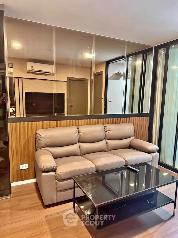 Modern living room with comfortable sofa and glass coffee table in stylish apartment.