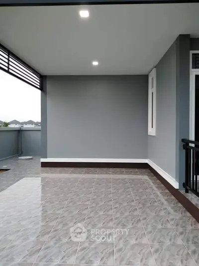 Spacious balcony with modern tiles and sleek railing, perfect for relaxation and outdoor enjoyment.
