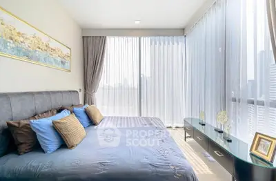 Luxurious bedroom with floor-to-ceiling windows and elegant decor in modern apartment.