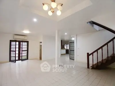 Spacious open-plan living area with staircase and modern lighting