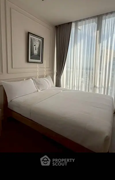 Elegant bedroom with large windows and modern decor, perfect for relaxation.