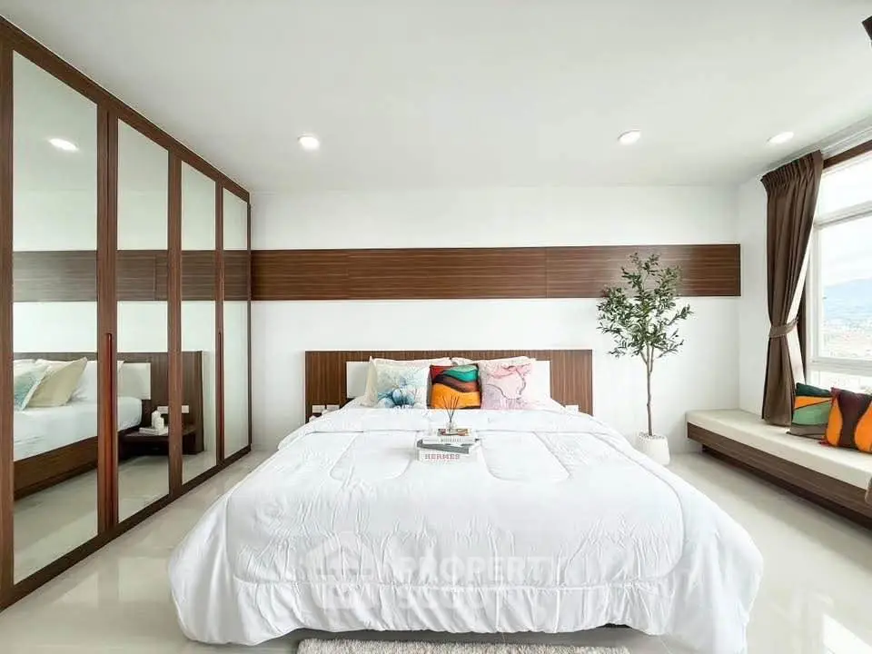 Spacious modern bedroom with large windows and stylish decor in a luxury apartment.