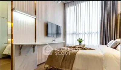 Modern bedroom with stylish decor, wall-mounted TV, and large window for natural light.