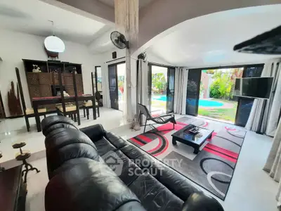 Spacious living room with pool view, modern decor, and open layout in luxury home.